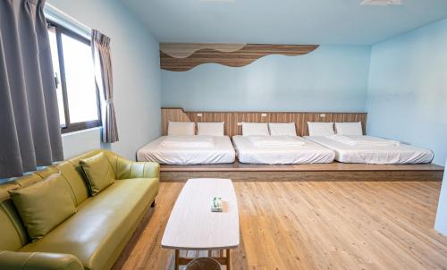 a living room with two beds and a couch at 戀海輕旅Ocean Pride Hostel in Xiaoliuqiu