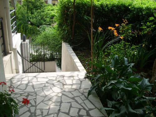 a garden with a stone walkway with flowers and plants at Apartments Dakovic in Kotor