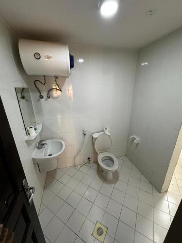 a bathroom with a toilet and a sink at Alreef Hotel Suits in Muscat