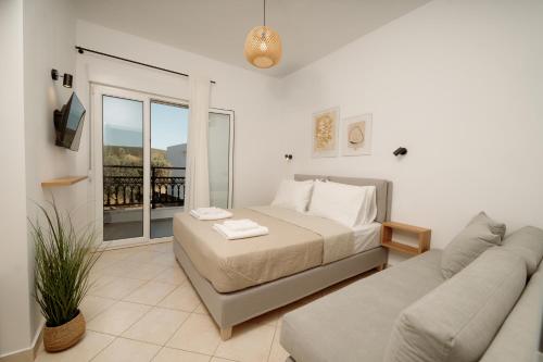 a bedroom with a bed and a couch and a window at White Nest Rooms in Potos
