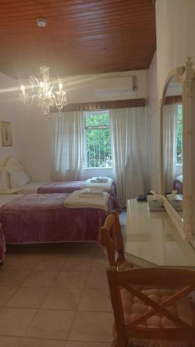a bedroom with a bed and a mirror and a chandelier at Nineta's House Sea View near the Airport in Artemida