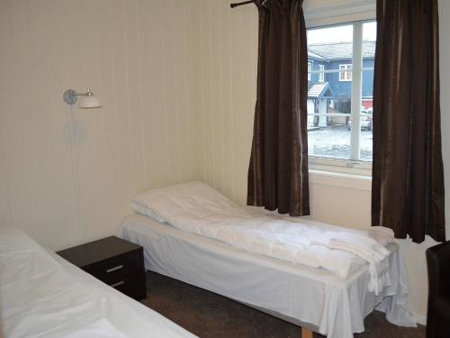 a room with two beds and a window at Grimstad Vertshus in Grimstad