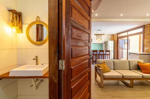 a bathroom with a sink and a couch in a room at Ocean View Beira-Mar no Centro de Canoa in Canoa Quebrada