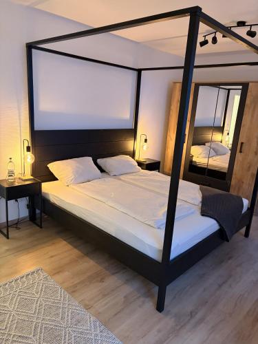 a bedroom with a canopy bed with a mirror at FeWo Grote in Warburg