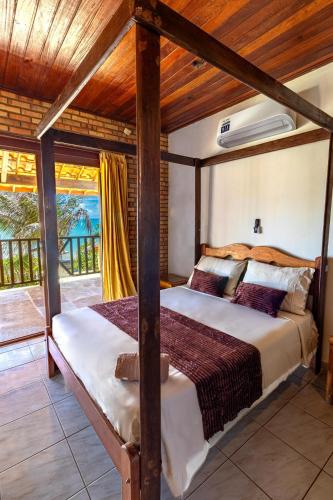 a bedroom with a bed with a wooden ceiling at Ocean View Beira-Mar no Centro de Canoa in Canoa Quebrada