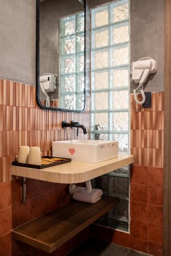 a bathroom with a sink and a mirror at REFUEL NEST Boutique Hotel in Danang