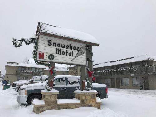 a sign for a snowflake motel in the snow at Snowshoe Motel in Frisco