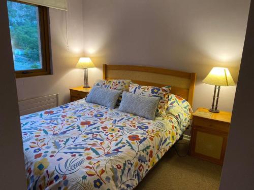 a bedroom with a bed with two lamps on tables at DEPARTAMENTOS TERMAS DE CHILLAN in Nevados de Chillan