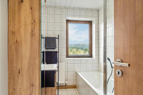 a bathroom with a bath tub and a window at Ferienwohnung Heimelig im Bayerwald in Haidmühle