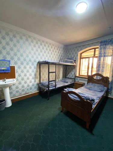a bedroom with two bunk beds and a sink at Hostel Inn in Andijan