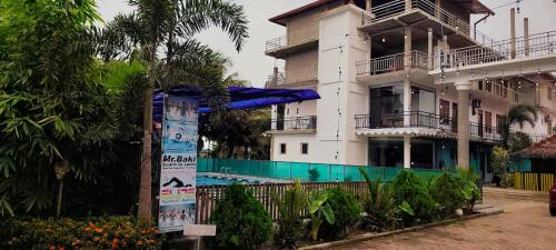 a building with a swimming pool in front of it at RS Green Barathi in Kilinochchi