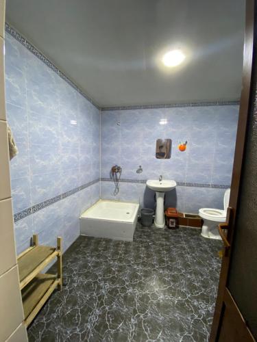 a bathroom with a tub and a toilet and a sink at Hostel Inn in Andijan