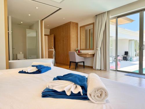 two beds with towels on them in a bedroom at Bali-Style 4 BR Private Pool Villa - Trichada in Phuket