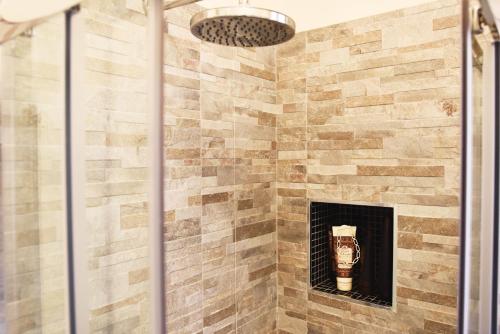 a shower with a stone wall in a bathroom at Residenza Elisabetta in Verona