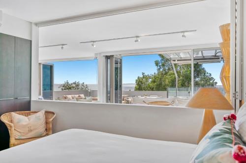 a bedroom with a bed and a large window at Picture Point Terraces in Noosa Heads