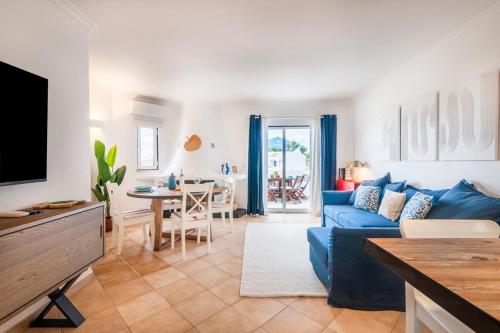 a living room with a blue couch and a table at Clube Albufeira: 2BR Prime Holidays Retreat in Albufeira