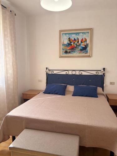a bedroom with a large bed with blue pillows at La Villetta in Lacona