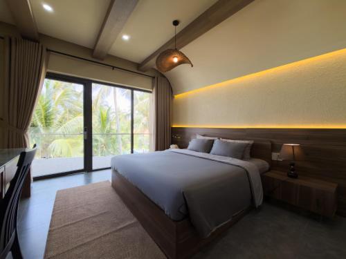 a bedroom with a large bed and a large window at SUNSHINE BEACH Resort in Mui Ne