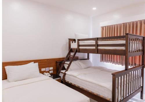 two bunk beds in a small room with a bed at Cris Inn Tagum in Tagum