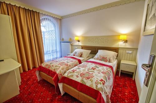 a hotel room with two beds and a window at Hotel Toporów in Białka Tatrzanska