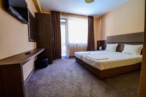 a hotel room with a bed and a television at Relax Houses in Ognyanovo