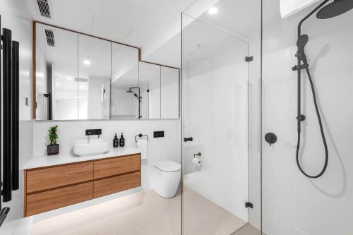 a bathroom with a toilet and a sink and a shower at Kove Apartment - B02 in Kiama