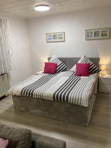 a bed with two pink pillows in a room at Schicke Ferienwohnung Philippsburg in Philippsburg