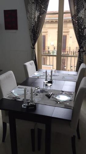 a black table with white chairs and a table and a window at B&B Paolo e Mariella in Palermo