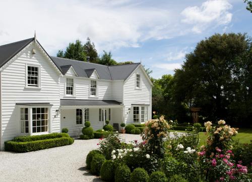 uma casa branca com um jardim em frente em Wyett House em Greytown