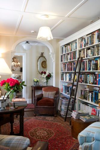 a living room with a library with book shelves filled with books at Wyett House in Greytown