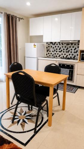a kitchen with a wooden table and two chairs at The Zef Apartment in Nadi