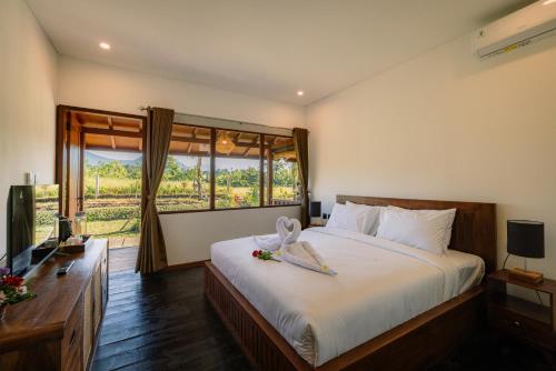 a bedroom with a large bed and a window at Tegal Wangi Penebel in Penebel