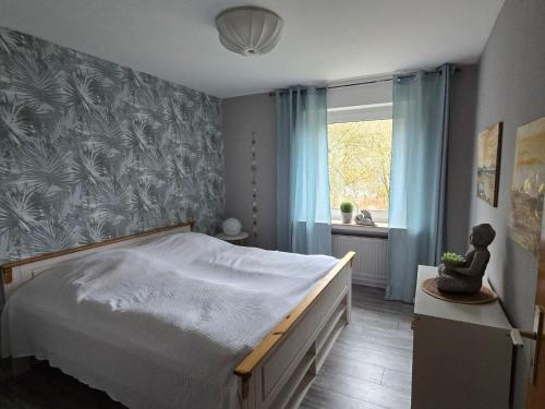 a bedroom with a large bed and a window at Märchenwerkstatt in Netphen