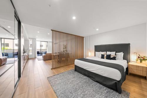 a bedroom with a large bed and a living room at Kove Apartment - G01 in Kiama