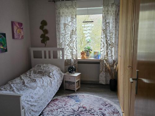 a bedroom with a bed and a window at Märchenwerkstatt in Netphen