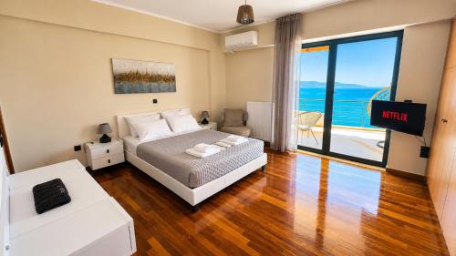 a bedroom with a bed and a view of the ocean at Seafront Luxury Apartment in Kalamata
