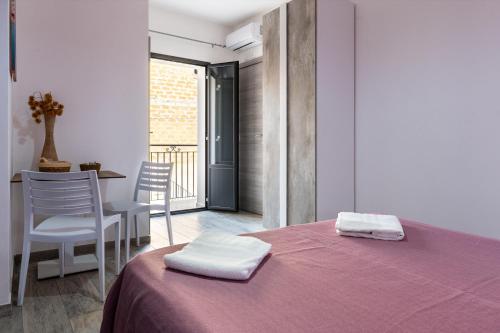 a room with a bed with two towels on it at Perla Marina Rooms in Realmonte