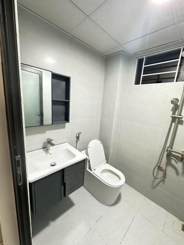 a white bathroom with a toilet and a sink at Nhà trọ bùi Thị lài in Dong Hoi
