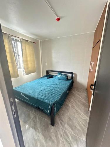 a bedroom with a bed with a blue comforter at Nhà trọ bùi Thị lài in Dong Hoi