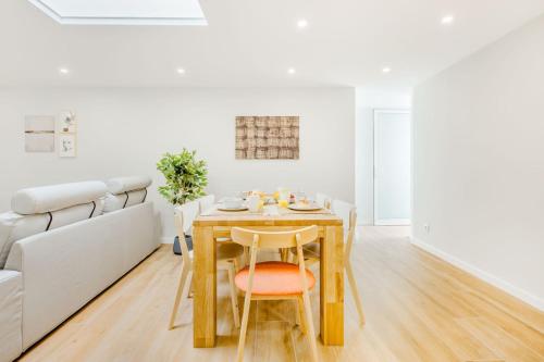 a dining room with a table and a couch at Espinho Beach 4 Stays with Terrace in Espinho