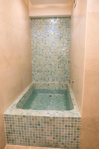 a bathroom with a tub with green tiles at The Grand Plaza Hotel Smouha in Alexandria