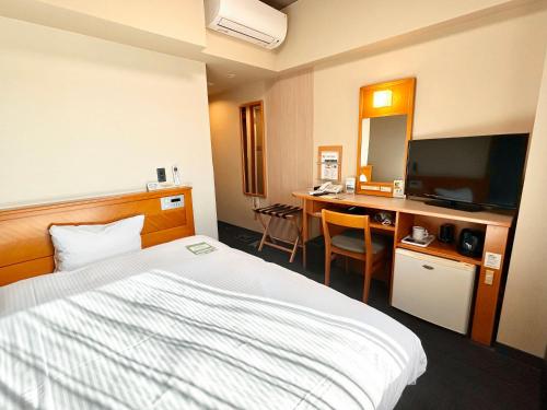 a hotel room with a bed and a desk at Hotel Route-Inn Kikugawa Inter in Kikugawa