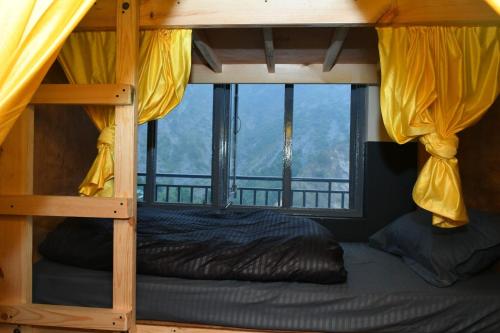 a bunk bed in a room with a window at Friends By Alizeh 2 0 Mcleodganj in Dharamshala