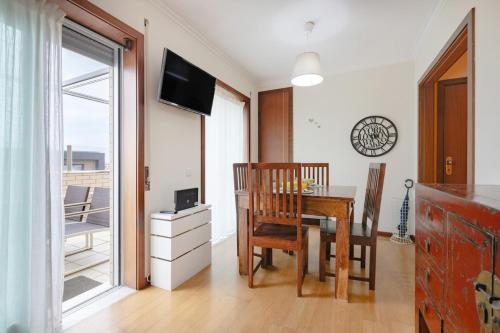 a dining room with a table and chairs and a window at Espinho Retreat with Balcony in Espinho