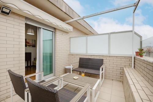 a patio with chairs and a bench on a balcony at Espinho Retreat with Balcony in Espinho