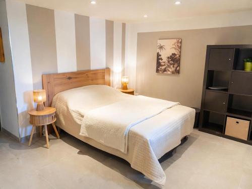 a bedroom with a white bed and a striped wall at La terrasse du romarin in Gorges