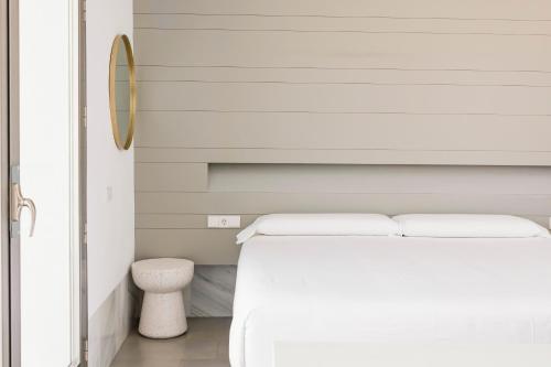 a bedroom with a white bed and a mirror at Las Negras Olivencia Natural in Las Negras
