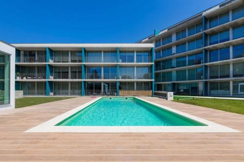 a swimming pool in front of a building at Olivia Maresia Homestay in Espinho