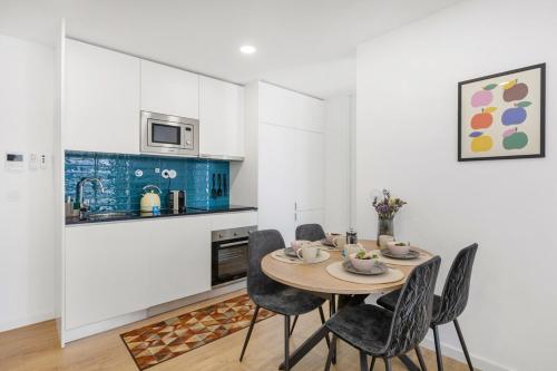 a kitchen with a table and chairs in a room at Olivia Maresia Homestay in Espinho