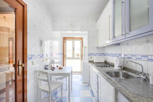 a white kitchen with a sink and a counter at Top Floor Retreat in Espinho in Espinho